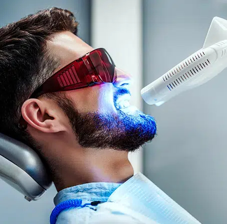 Happy patient receiving teeth whitening at dental office in Cary NC