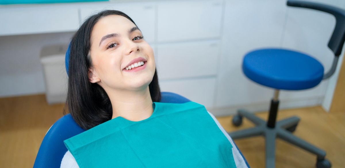 young woman smiling in a dental office after bonding procedure