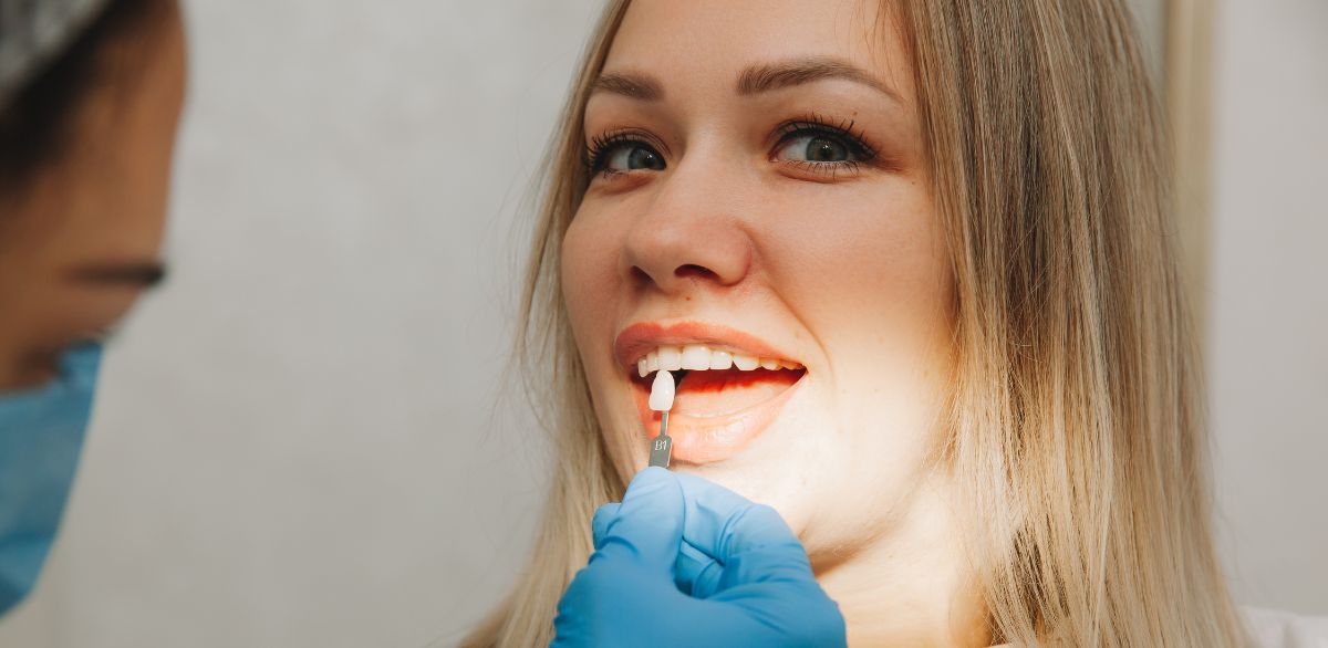 woman getting porcelain veneer matched at a dental appointment