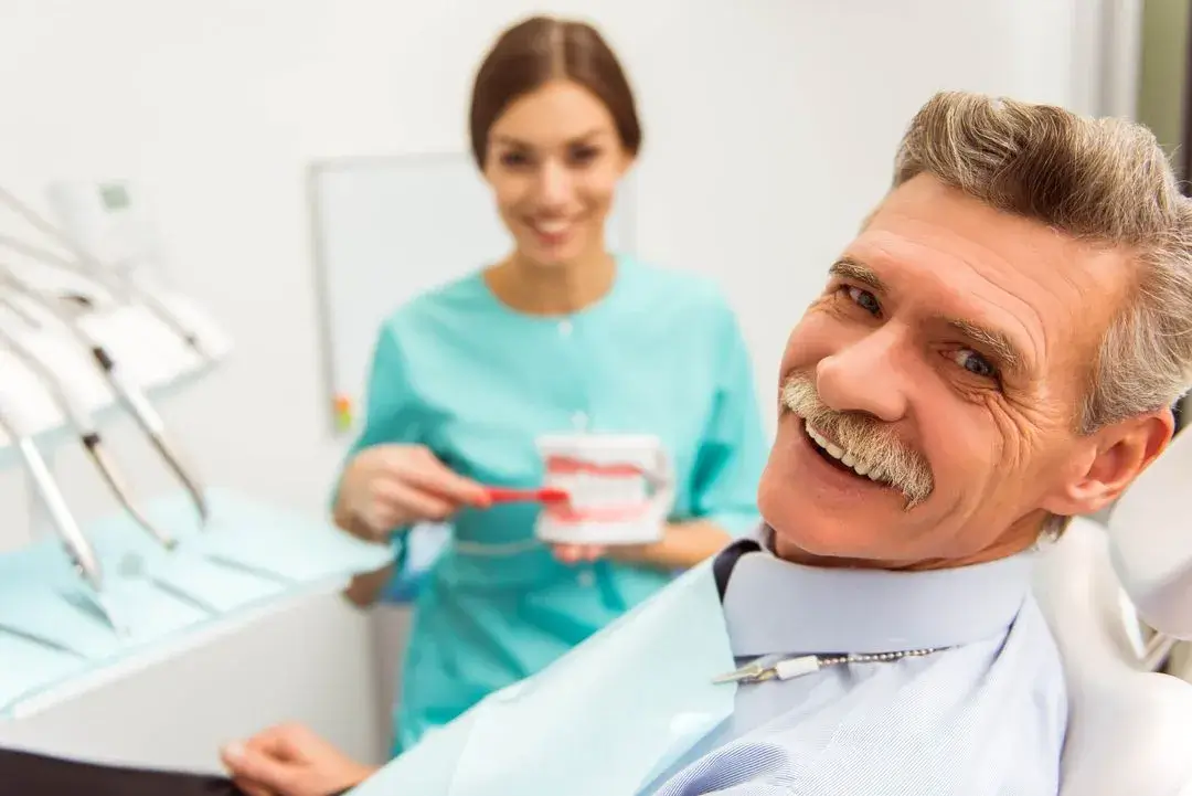 senior-patient-asking-questions-about-how-to-care-for-auburn-traditional-dentures