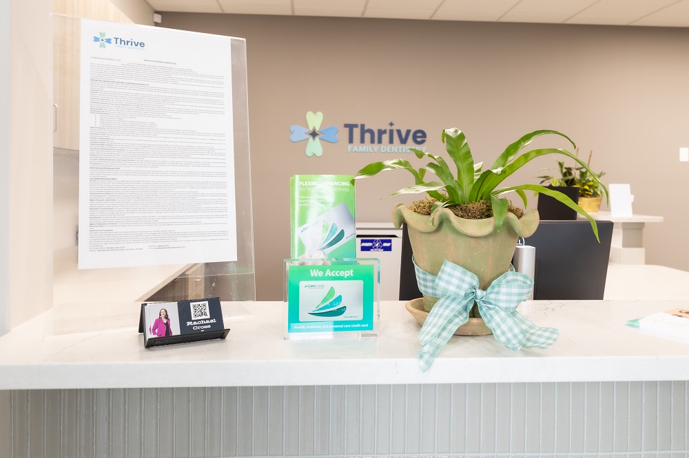 Thrive Family Dentistry of Auburn reception counter with plant and signage