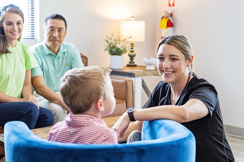 Friendly dental staff welcoming child and family at Auburn dental office